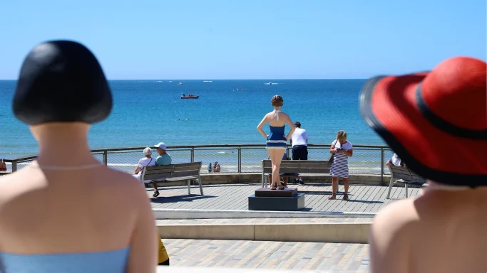 Les ables d'Olonne Statue d'une femme en maillot vintage, promenade en bord de mer, avec un enfant et des passants.
